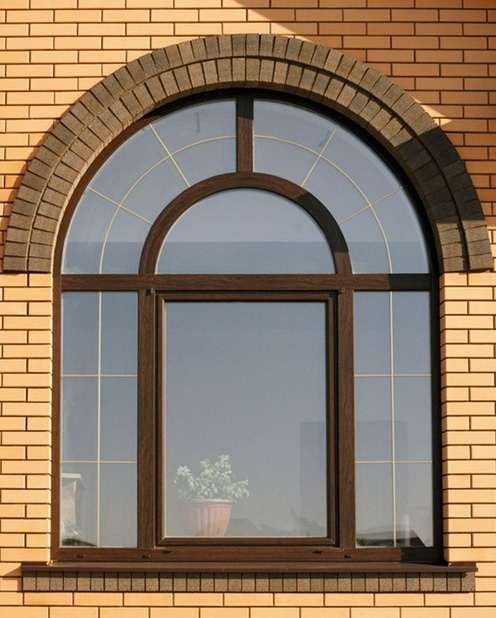 Коричневое арочное окно на фасаде дома