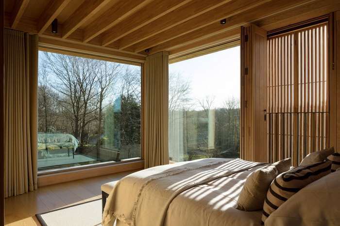 Деревянные окна углом в спальне